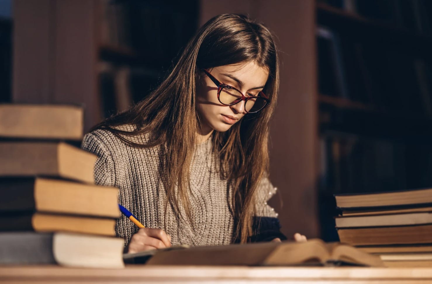 Estudiante concentrada preparando un examen oficial con libros y planificación